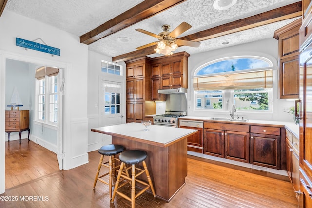 817 S Ocean Ave, Seaside Park, NJ 08752 - kitchen featuring dishwasher, a textured ceiling, beamed ceiling, high end stove, and a breakfast bar