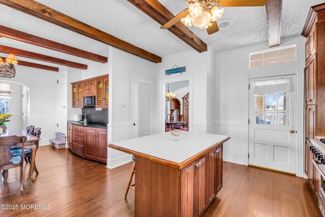 817 S Ocean Ave, Seaside Park, NJ 08752 - kitchen with black microwave, arched walkways, dark wood-type flooring, ceiling fan, and beamed ceiling