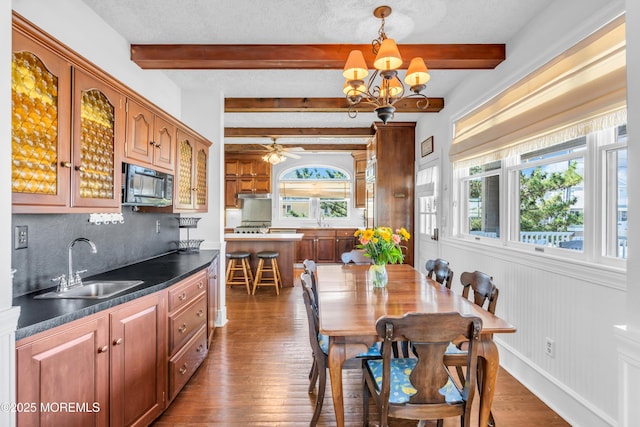 817 S Ocean Ave, Seaside Park, NJ 08752 - dining room with dark wood finished floors, beamed ceiling, a chandelier, and ceiling fan
