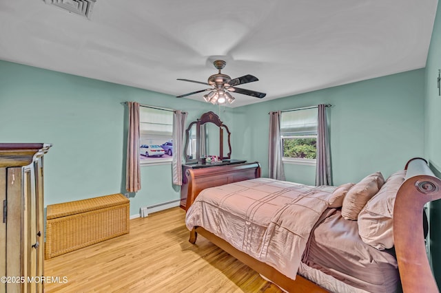 255 Cherokee Trl, Forked River, NJ 08731 - bedroom featuring baseboard heating, wood finished floors, a ceiling fan, and baseboards