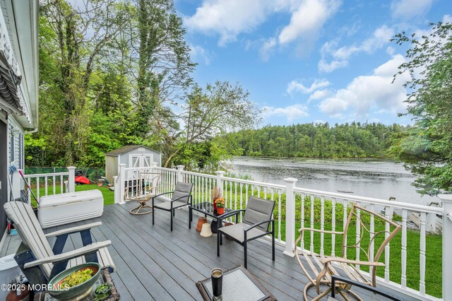 255 Cherokee Trl, Forked River, NJ 08731 - wooden terrace featuring a water view, a shed, a view of trees, and an outdoor structure