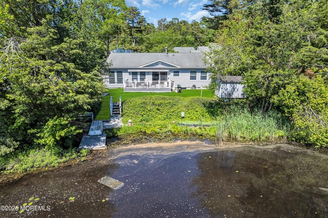 255 Cherokee Trl, Forked River, NJ 08731 - view of front of property featuring a front yard, a deck with water view, a storage shed, and an outdoor structure
