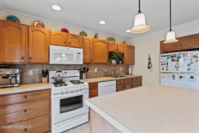 kitchen with white appliances, a sink, crown molding, decorative backsplash, and light countertops