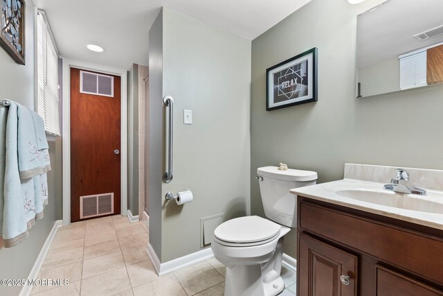 bathroom with toilet, tile patterned flooring, vanity, and baseboards