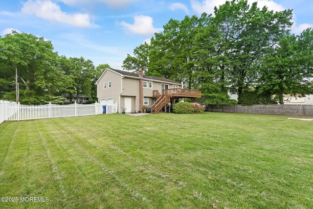 view of yard featuring stairway, a deck, and an attached garage