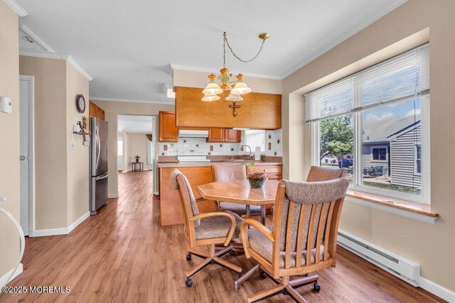 25 Elmswell Ave, Manchester, NJ 08759 - dining room with baseboard heating, crown molding, a chandelier, light wood-style flooring, and baseboards