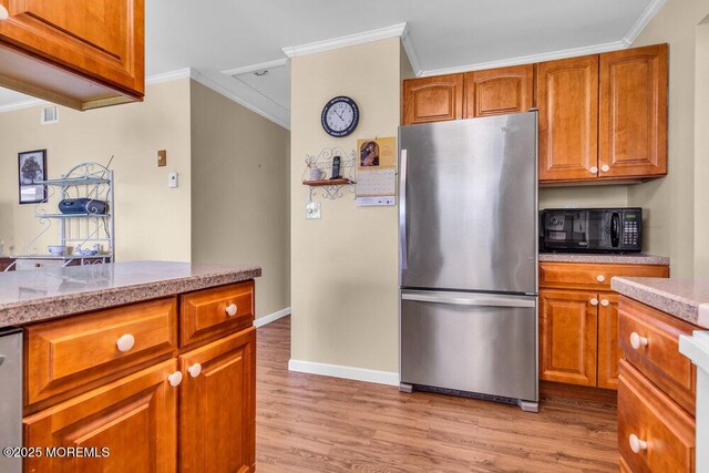 25 Elmswell Ave, Manchester, NJ 08759 - kitchen with freestanding refrigerator, ornamental molding, light wood-type flooring, brown cabinets, and tile counters