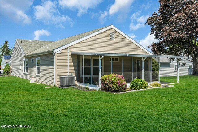 25 Elmswell Ave, Manchester, NJ 08759 - rear view of property featuring a sunroom, central air condition unit, a lawn, and a shingled roof