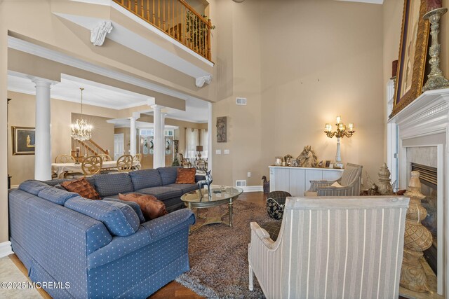 5 Chadwick Ct, Waretown, NJ 08758 - living area with decorative columns, baseboards, a fireplace, a high ceiling, and a chandelier