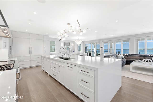 948 Lagoon Ln S, Mantoloking, NJ 08738 - kitchen featuring a sink, high end stainless steel range, light wood-type flooring, white cabinetry, and a chandelier