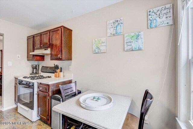 82 Briarwood Ct, Howell, NJ 07731 - kitchen featuring white range with gas cooktop, under cabinet range hood, light countertops, and a desk