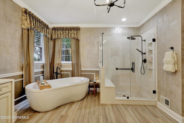 50 Hedgerow Ln, Manalapan, NJ 07726 - bathroom with ornamental molding, a shower stall, a freestanding tub, a chandelier, and wood finished floors