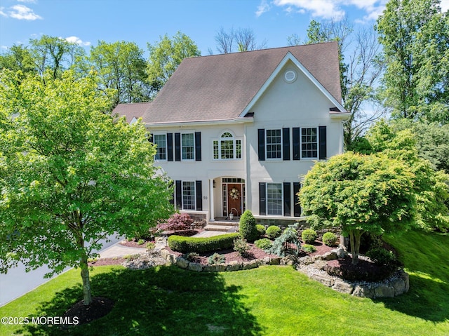 50 Hedgerow Ln, Manalapan, NJ 07726 - colonial-style house featuring a front yard, stucco siding, and a shingled roof