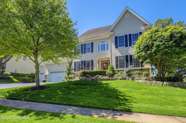 50 Hedgerow Ln, Manalapan, NJ 07726 - colonial inspired home featuring stucco siding, a front lawn, driveway, and an attached garage