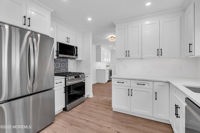 kitchen featuring stainless steel appliances, tasteful backsplash, white cabinetry, recessed lighting, and light wood finished floors