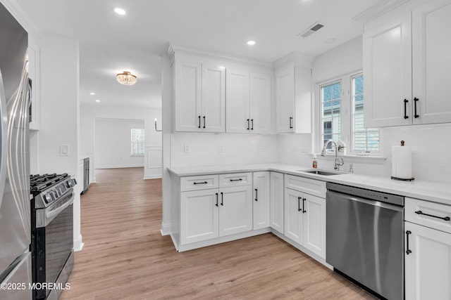 kitchen with stainless steel appliances, a sink, recessed lighting, light wood-type flooring, and light countertops