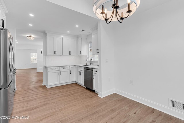 kitchen with appliances with stainless steel finishes, a chandelier, recessed lighting, white cabinets, and light wood-type flooring