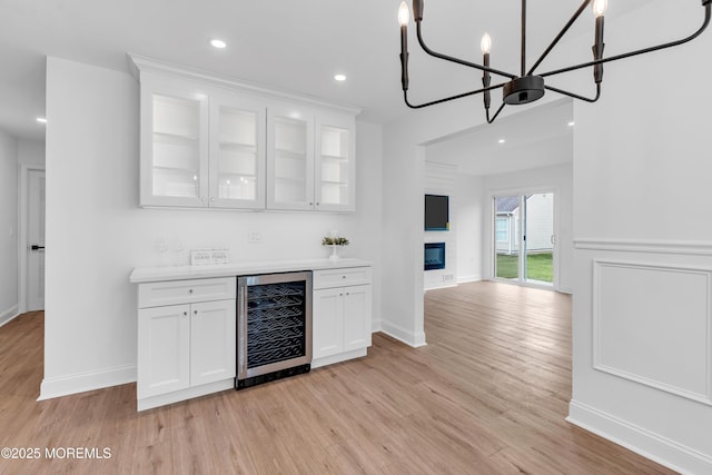 indoor dry bar with wine cooler, light wood-style flooring, a chandelier, recessed lighting, and baseboards