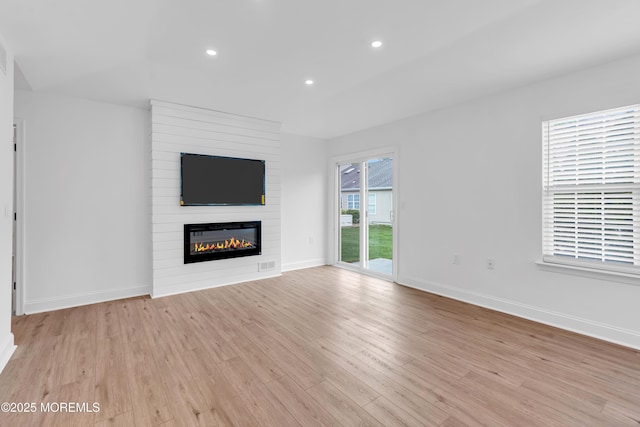 unfurnished living room featuring light wood-style floors, a fireplace, baseboards, and recessed lighting