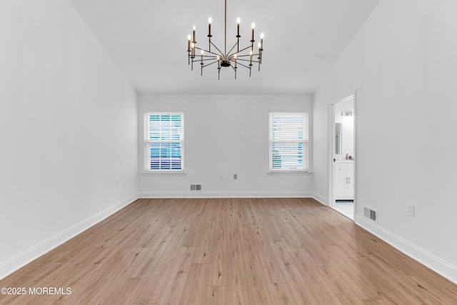 unfurnished dining area with a chandelier, light wood-style flooring, and baseboards
