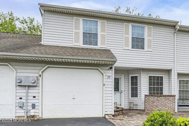view of front facade with a garage and asphalt driveway