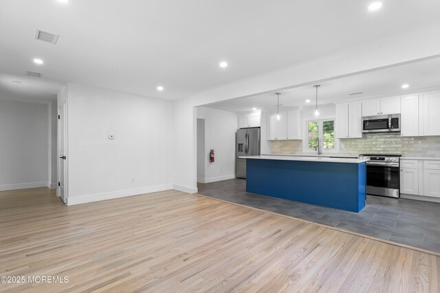 316 Hillside Dr, Neptune Township, NJ 07753 - kitchen with stainless steel appliances, light wood finished floors, recessed lighting, decorative backsplash, and a kitchen island