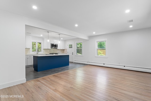 316 Hillside Dr, Neptune Township, NJ 07753 - kitchen featuring stainless steel microwave, recessed lighting, white cabinetry, a kitchen island, and tasteful backsplash