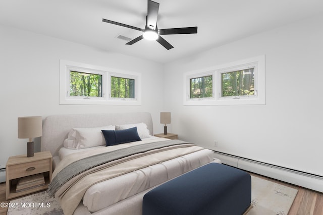 316 Hillside Dr, Neptune Township, NJ 07753 - bedroom featuring a baseboard heating unit, wood finished floors, and a ceiling fan
