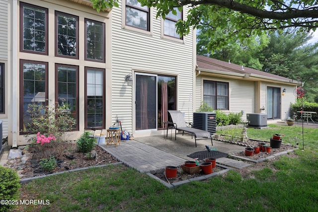 rear view of house featuring central AC unit, a patio area, and a yard