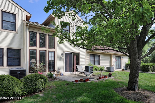 back of house featuring central air condition unit, a yard, and a patio area
