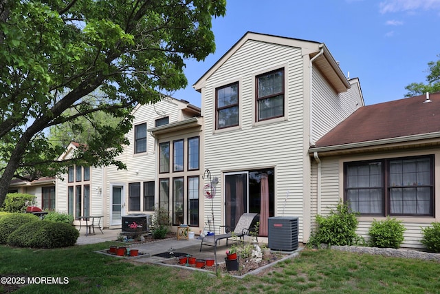rear view of property with central AC, a patio, and a yard