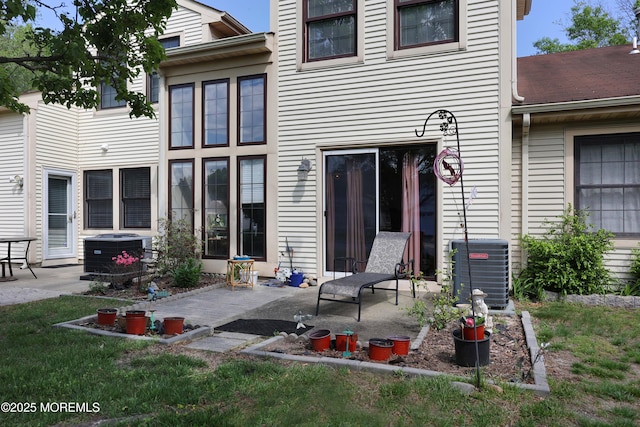 rear view of house featuring central air condition unit, a patio area, and a lawn
