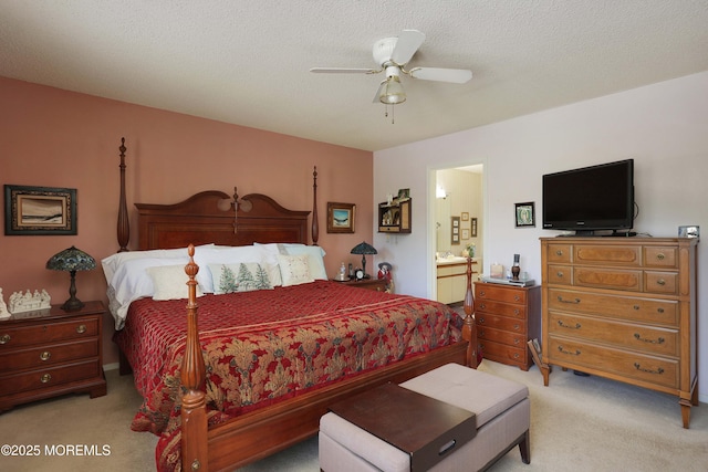 carpeted bedroom with ensuite bathroom and ceiling fan