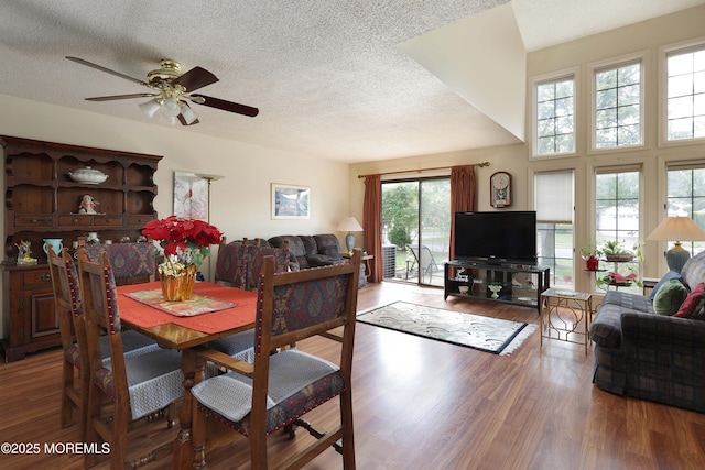 dining space featuring wood finished floors, a textured ceiling, and ceiling fan