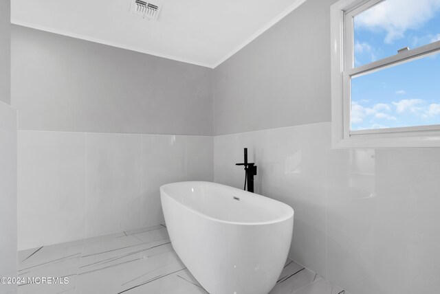 6 Afton Rd, Jackson, NJ 08527 - full bathroom with ornamental molding, a soaking tub, marble look tiles, a wainscoted wall, and tile walls