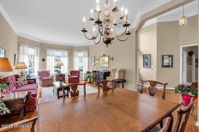 dining room with crown molding, a chandelier, and wood finished floors
