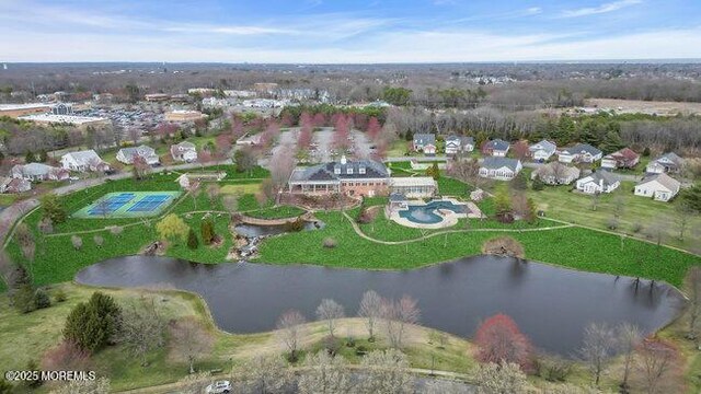 aerial view of property's location featuring a nearby body of water and nearby suburban area
