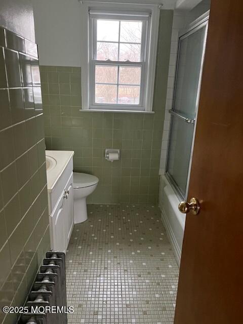 79 Davidson Mill Rd, North Brunswick, NJ 08902 - full bath featuring radiator, tile patterned flooring, toilet, vanity, and tile walls