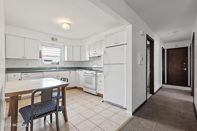 kitchen featuring white appliances, under cabinet range hood, a sink, and white cabinetry