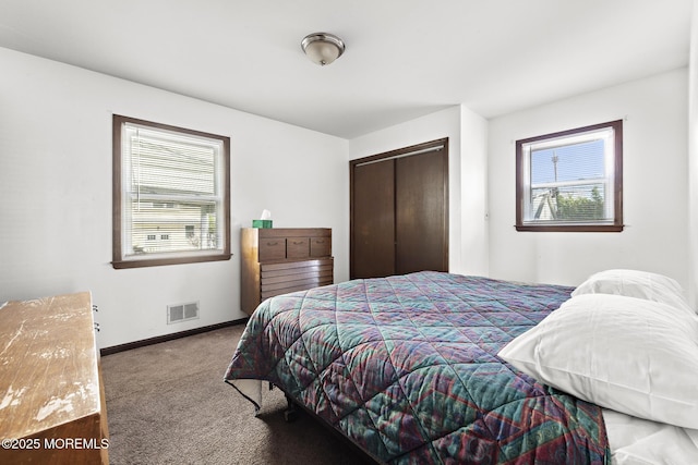 carpeted bedroom with baseboards and a closet