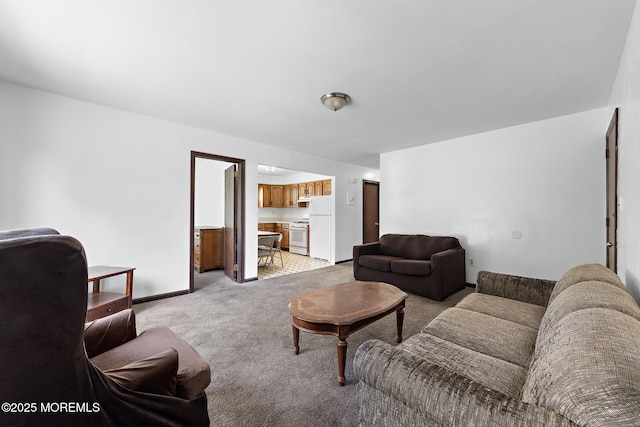 living area with light colored carpet and baseboards