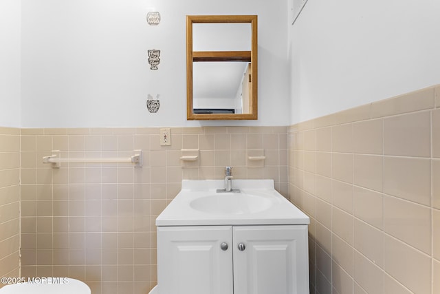 bathroom with tile walls, vanity, and toilet