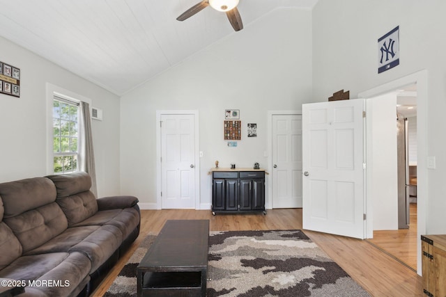 living area with ceiling fan, light wood-type flooring, and high vaulted ceiling