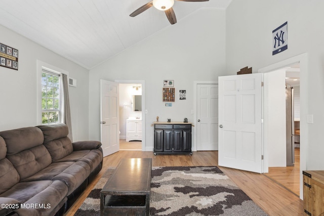 living room featuring ceiling fan, light wood-style flooring, and high vaulted ceiling