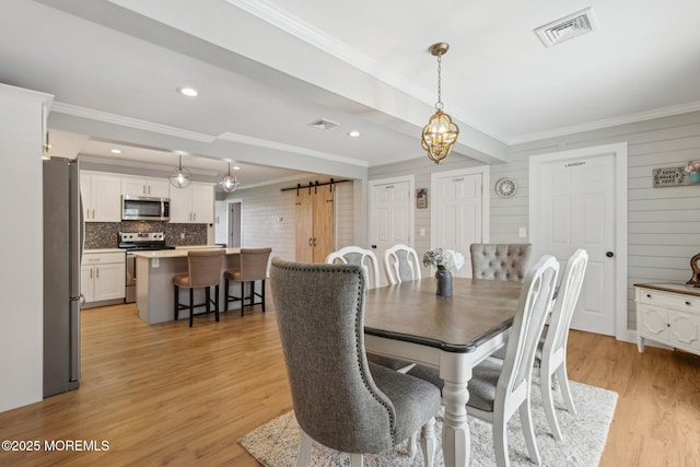 dining area with a barn door, crown molding, light wood-type flooring, a chandelier, and recessed lighting