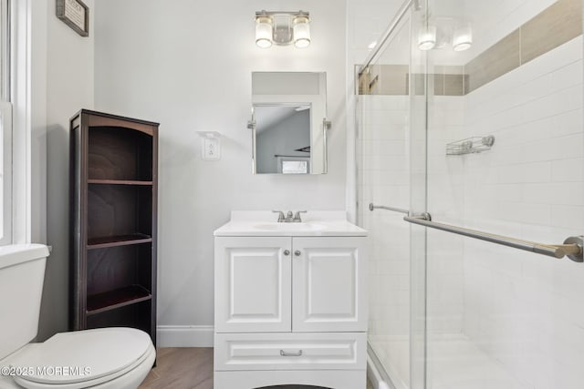 full bath featuring a stall shower, toilet, and vanity