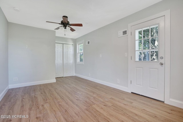 foyer entrance with light wood-style flooring, baseboards, and ceiling fan