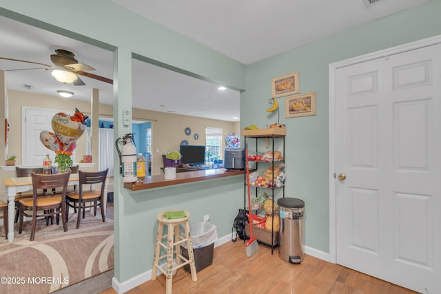 707 Zlotkin Cir Unit 7, Freehold, NJ 07728 - kitchen with wood finished floors, baseboards, a ceiling fan, and a breakfast bar