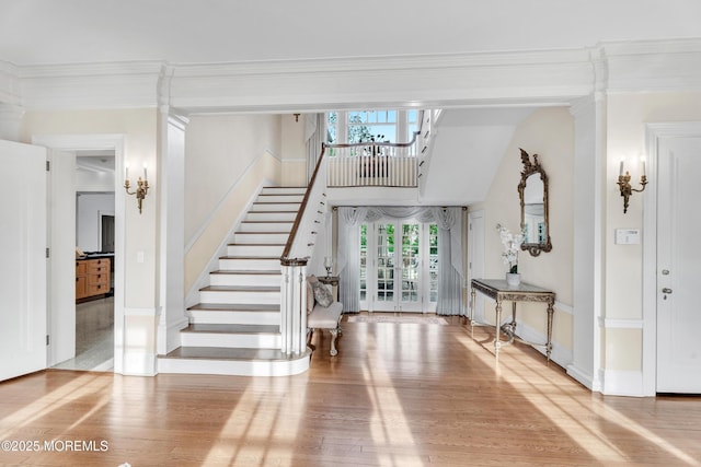 entrance foyer featuring wood finished floors, stairs, ornamental molding, and baseboards