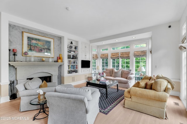 living room with light wood finished floors, healthy amount of natural light, baseboards, and recessed lighting